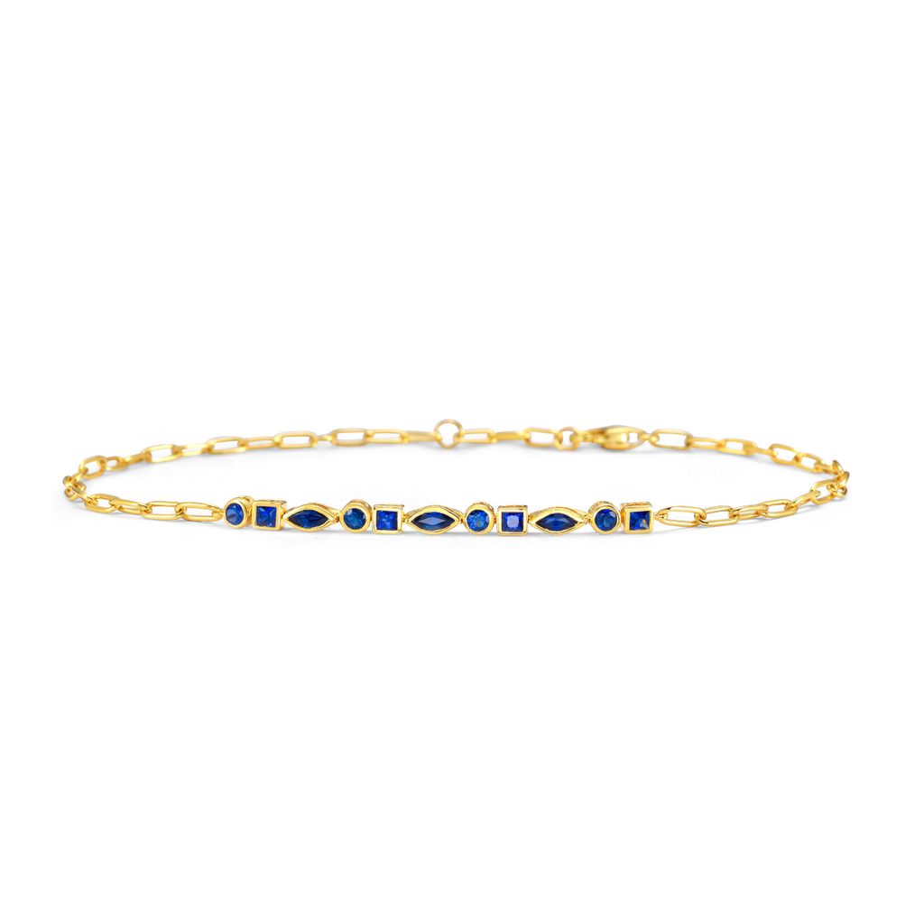 Gold bracelet with blue stones on a white background